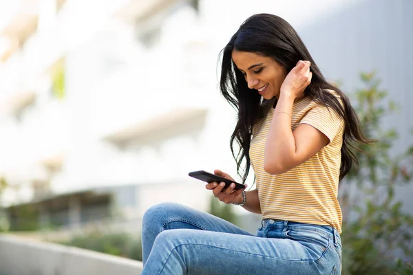 Zijportret Lachende Jonge Vrouw Zitten Buiten Kijken Naar Mobiele Telefoon — Stockfoto