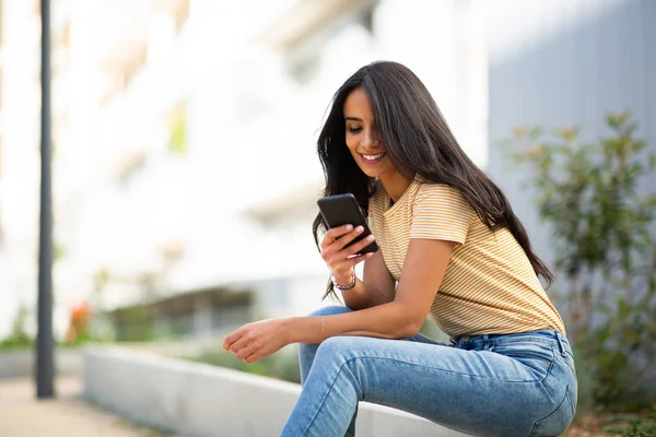 Retrato Lateral Jovem Sorrindo Mulher Sentada Fora Olhando Para Telefone — Fotografia de Stock