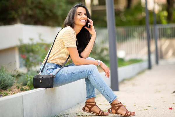 Retrato Lateral Cuerpo Entero Mujer Joven Sentada Afuera Sonriendo Hablando —  Fotos de Stock