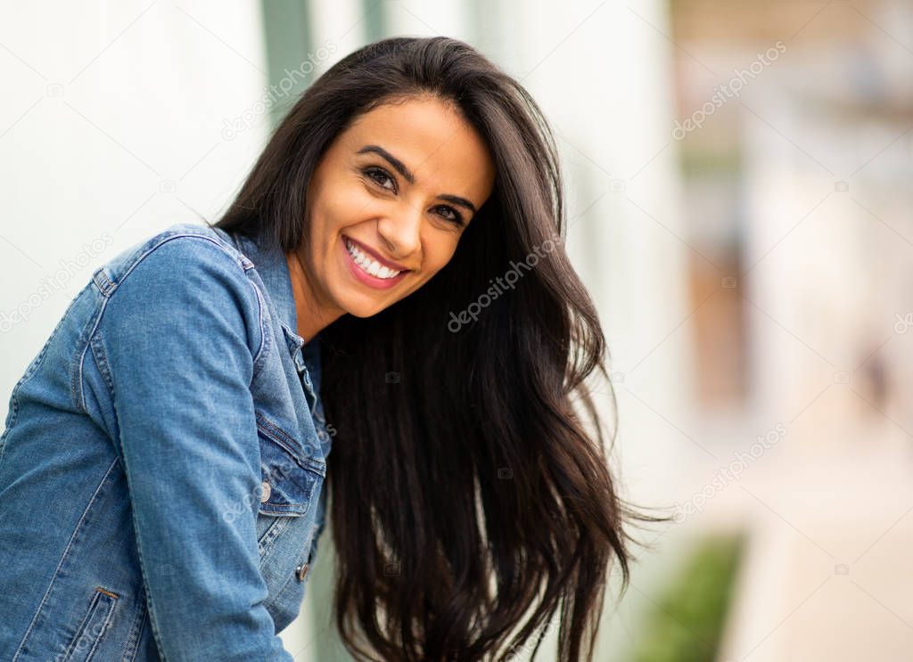 Close up side portrait beautiful young latin woman smiling outside