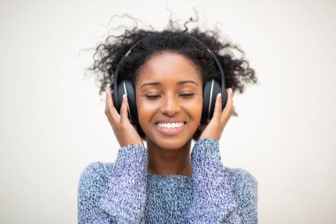 Ön tarafta, kulaklıkları ve gözleri kapalı müzik dinleyen Afro-Amerikan genç kadın portresi var.