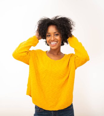 Yakın çekimde gülümseyen Afro-Amerikan kadın elleri saçlarında, izole beyaz arka planda.