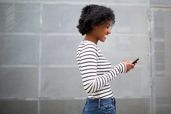 Zijportret Glimlachende Jonge Zwarte Vrouw Zoek Naar Mobiele Telefoon — Stockfoto