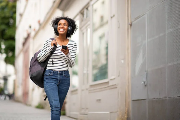 Retrato Sonriente Mujer Afroamericana Caminando Con Bolso Teléfono Celular Escuchando — Foto de Stock