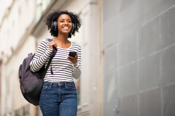 Retrato Sonriente Mujer Afroamericana Caminando Con Bolsa Teléfono Escuchando Música — Foto de Stock