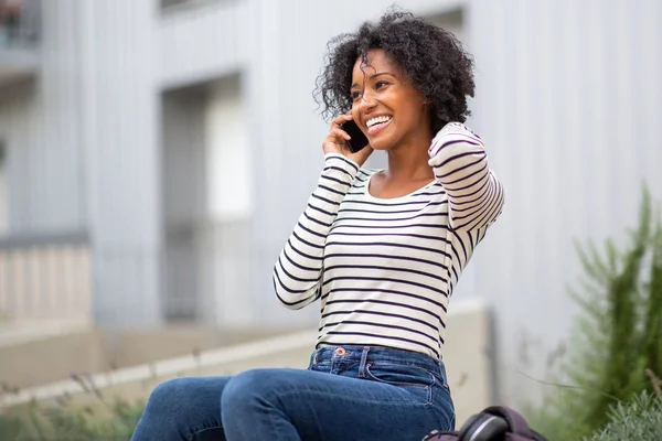 Porträtt Leende Ung Svart Kvinna Sitter Utanför Prata Med Mobiltelefon — Stockfoto