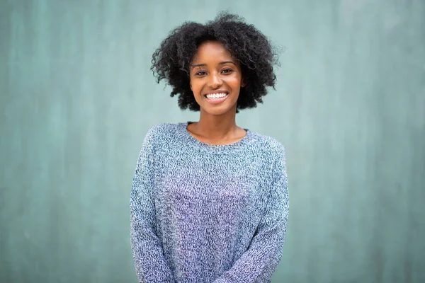 フロントポートレート笑顔若い黒人女性によって緑の背景 — ストック写真