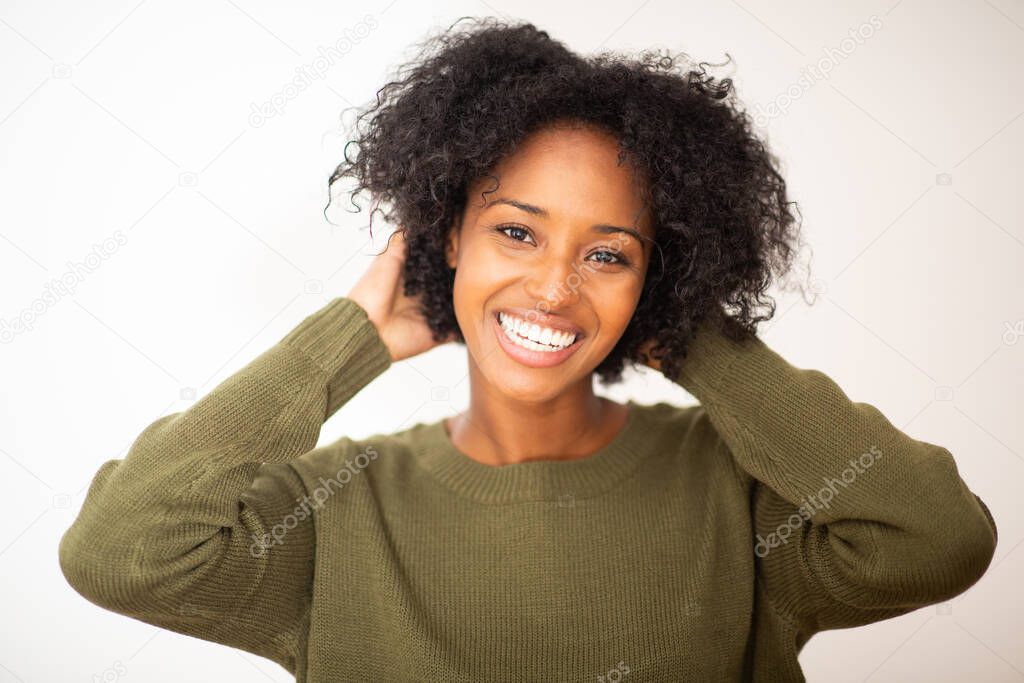 Close up portrait happy young african american woman with hands in hair by isolated white background