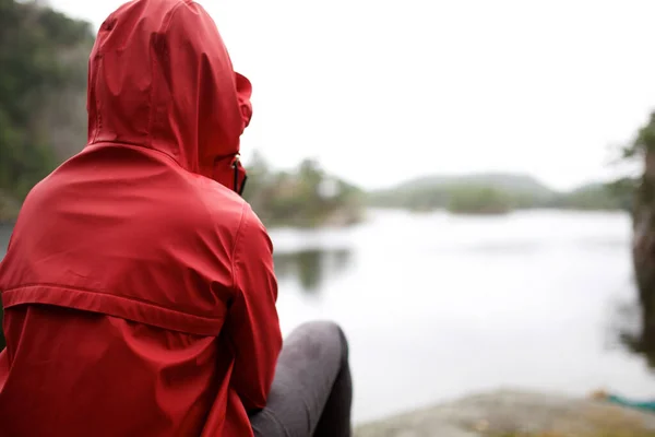 雨天坐在湖边的人身后 — 图库照片