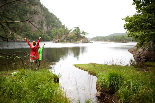 腕を上げて応援する湖で母娘の後ろからの肖像 — ストック写真