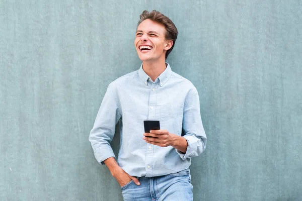 Portret Gelukkige Jongeman Leunend Tegen Muur Met Mobiele Telefoon Weg — Stockfoto