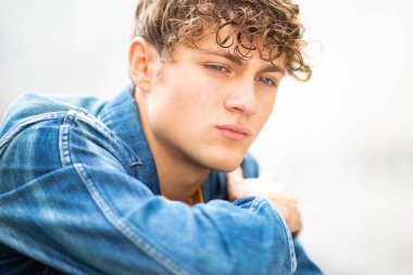 Kapalı portre yakışıklı genç adam dışarıda yalnız oturuyor. 