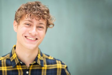 Bulanık yeşil arka planda mutlu genç adam portresini kapat