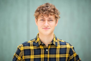 Bulanık yeşil arka planda genç adamın portresini kapat