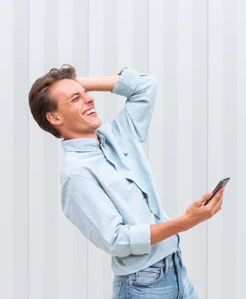 Side Portret Szczęśliwy Młody Człowiek Trzyma Telefon Komórkowy Śmiech — Zdjęcie stockowe