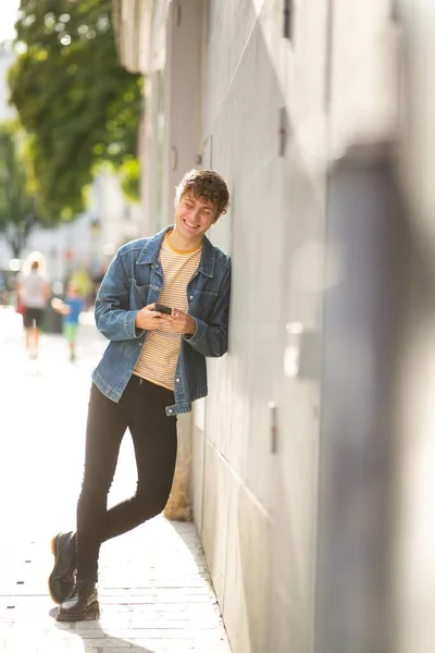 Retrato Comprimento Total Sorrindo Jovem Olhando Para Telefone Celular Enquanto — Fotografia de Stock