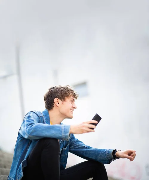 Portrait Jeune Homme Heureux Assis Extérieur Avec Cellphon — Photo