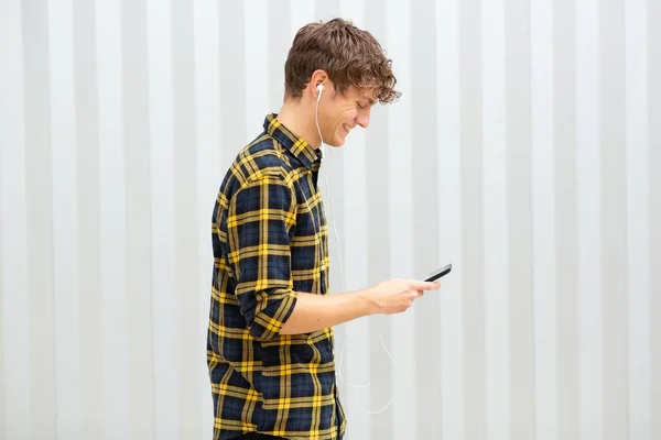 Zijportret Lachende Jongeman Wandelen Met Mobiele Telefoon Luisteren Naar Muziek — Stockfoto