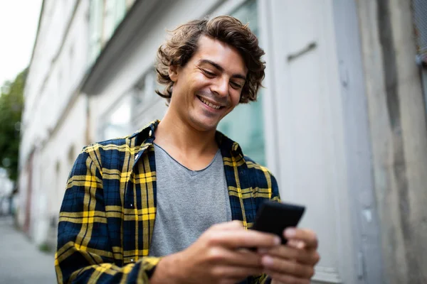 Kapalı Kapılar Ardında Yürüyen Mutlu Genç Adam Cep Telefonuna Bakıyor — Stok fotoğraf