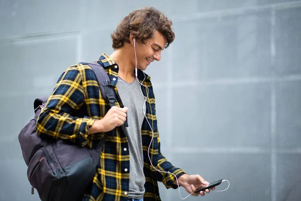 Zijportret Lachende Jongeman Loopt Met Mobiele Telefoon Oortjes Buiten — Stockfoto