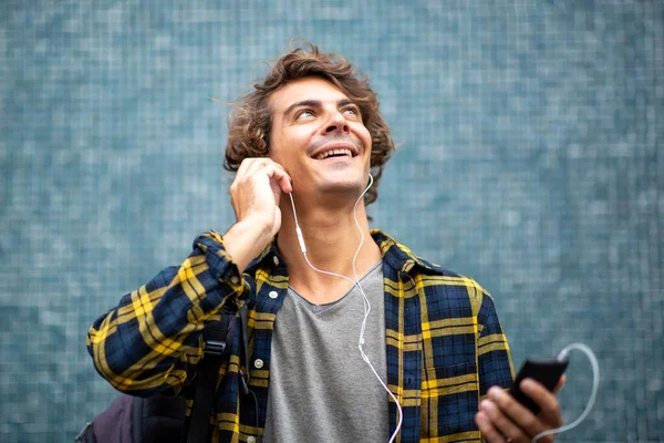 Zblízka Usměvavý Mladý Muž Poslech Hudby Mobilním Telefonem Sluchátky Vzhlíží — Stock fotografie