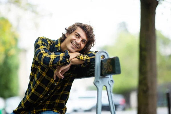 Portrét Usměvavý Mladý Muž Sedící Městské Lavičce — Stock fotografie