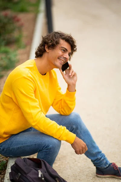 Ritratto Felice Giovane Seduto Fuori Con Borsa Parlare Con Telefono — Foto Stock