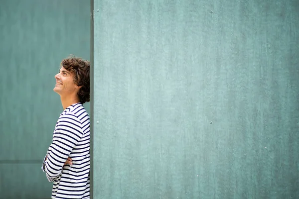 Profile Portrait Young Smiling Man Leaning Green Wall Looking — Stock Photo, Image