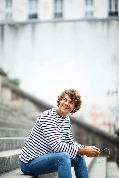 Portrait Jeune Homme Souriant Relaxant Sur Les Marches Écoutant Musique — Photo