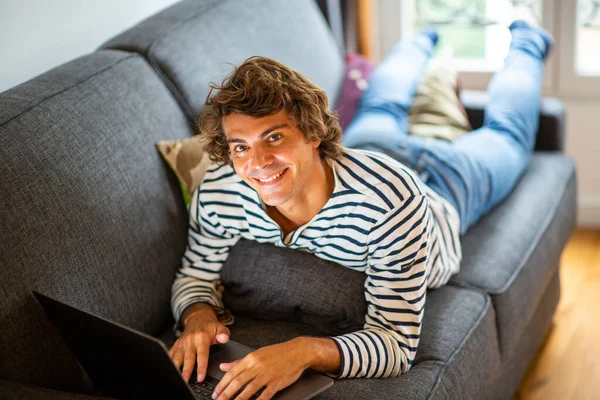Portret Jongeman Ontspannen Bank Thuis Met Behulp Van Laptop Computer — Stockfoto
