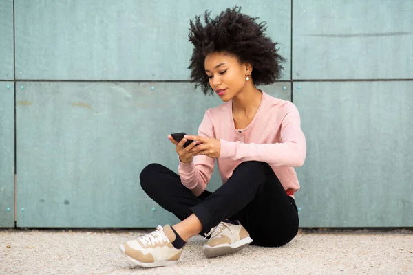 Retrato Joven Afroamericana Mujer Sentada Suelo Fuera Mirando Teléfono Móvil — Foto de Stock