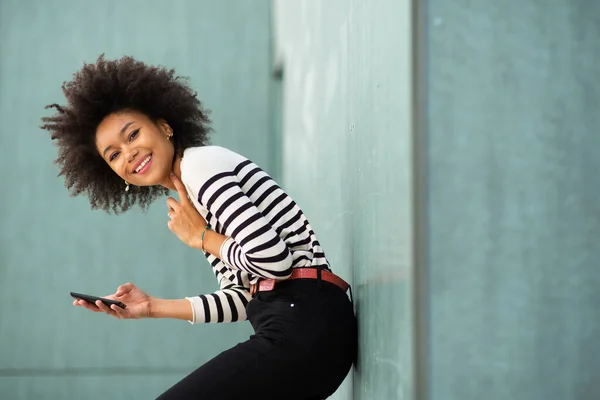 Seitenporträt Glückliche Junge Afrikanisch Amerikanische Frau Lehnt Mit Handy Wand — Stockfoto