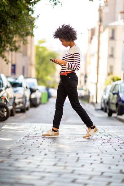 Retrato Lateral Largo Joven Afroamericana Mujer Caminando Calle Mirando Teléfono —  Fotos de Stock