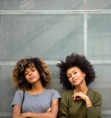 İki havalı Afro saçlı Afro-Amerikan kadının portresi.