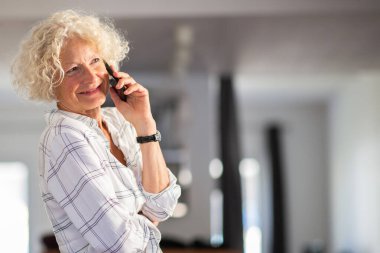 Evde cep telefonuyla konuşan yandaki portreyi kapat.