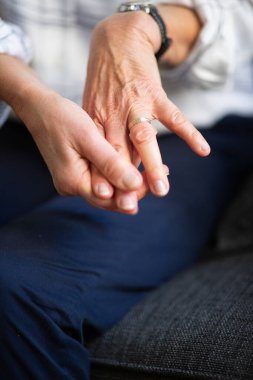 Yaşlı kadın ellerinin parmaklarına dokunduğu portreyi kapat.