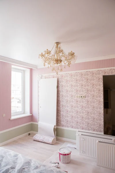 Room with pink wallpaper. The room is under repair.