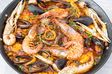 Karidesli, kalamarlı, sepyalı, midyeli ve maymunbalıklı tipik İspanyol paella 'sının detayları.