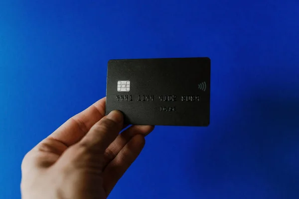Mavi arka planda siyah banka kartı var.