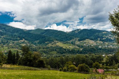 Dağlar yeşil çimenler yeşil ağaçlar mavi gökyüzü