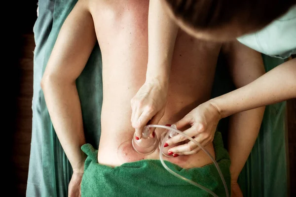 Kadın eli, erkeğe masaj önleyici verir.