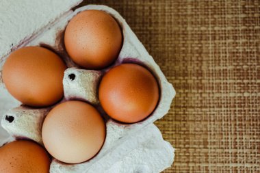 Hasır arka planda kağıt tepside beş ev yumurtası. Protein. Çiğ yumurta. Bir tavuk. Paskalya. konsept