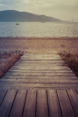 Körfezdeki sakin okyanusta sahil yürüyüşü ve kumlu sahile bakış açısı. Bulutlu bir günde kumsal. Rahatlamak için güzel bir yer..