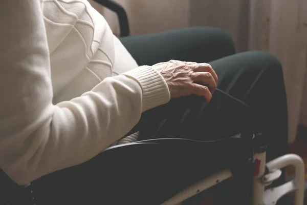 Bir huzurevinde, klinikte ya da bir evde tekerlekli sandalyede oturan yaşlı bir kadının eli. Engellilik, bağımlılık, bunama, Alzheimer gibi sağlık ve sağlık sorunları olan kişiler