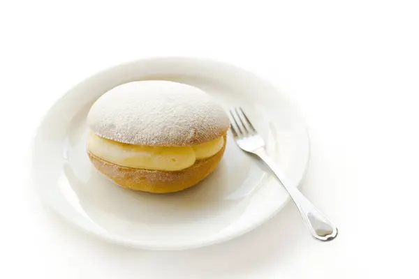 用奶油和糖粉在盘子里用叉子吃面包 — 图库照片