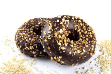 Beyaz arka planda ceviz kırıntılarıyla süslenmiş lezzetli, jöleli çörekler..