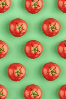 Yeşil arka planda renkli kırmızı domateslerin yaratıcı dikey deseni. Sağlıklı gıda, yaratıcı mutfak, yaşam tarzı ve sağlık kavramı.