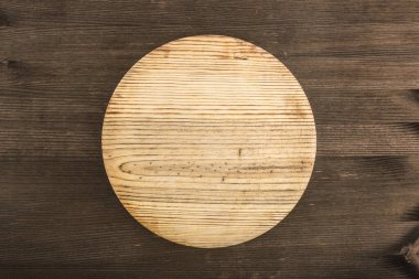 Eski ahşap bir masada, kırsal ahşap bir tabağın üst görüntüsü. Yemek ya da mesaj bırakmak için boş tabak. Doku veya arkaplan olarak kullanılacak grafik kaynak.