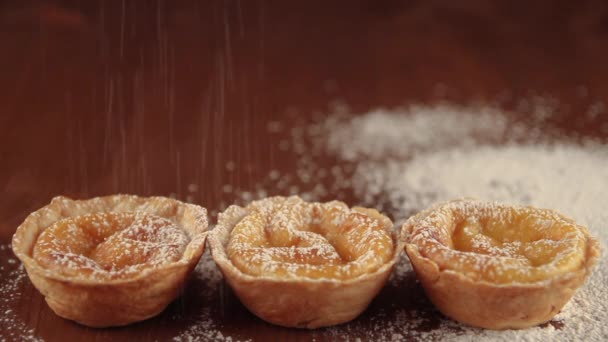 素朴なダークウッドのテーブルの上に砂糖を振りかけるおいしい自家製ベレンケーキ ベレンの職人のペストリー ポルトガルの伝統的なデザート クリームケーキ — ストック動画
