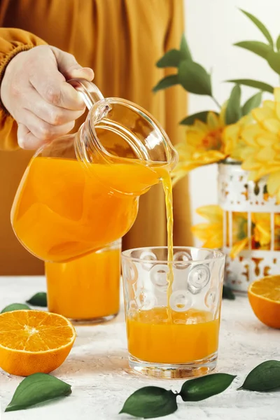 Een Mooie Vrouw Een Oranje Jurk Schenkt Vers Gemaakt Sinaasappelsap — Stockfoto